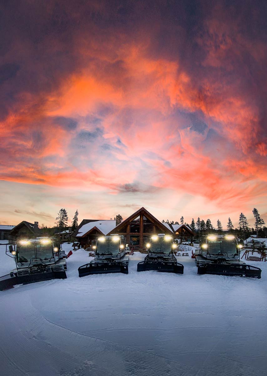 Five of Breckenridge's sno-cats lined up under a colorful sunrise