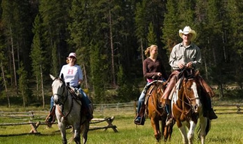 Four people horseback riding at Devil's Thumb Ranch
