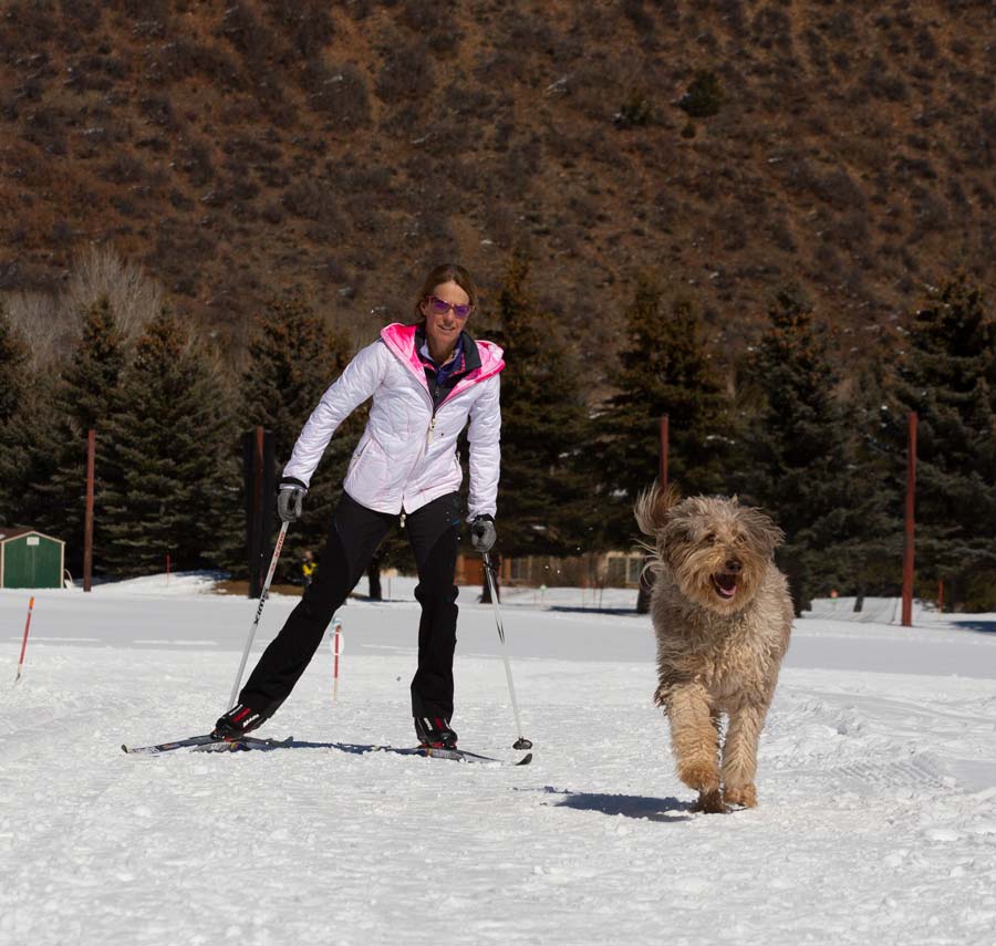 Cross country skier with her dog on the trails at Aspen Snowmass